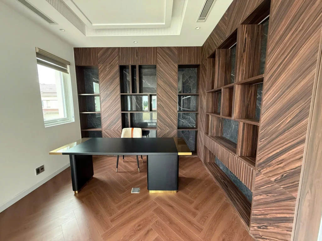 Phòng làm việc biệt thự Saroma Villa với tường ốp gỗ tự nhiên và bàn làm việc hiện đại. 