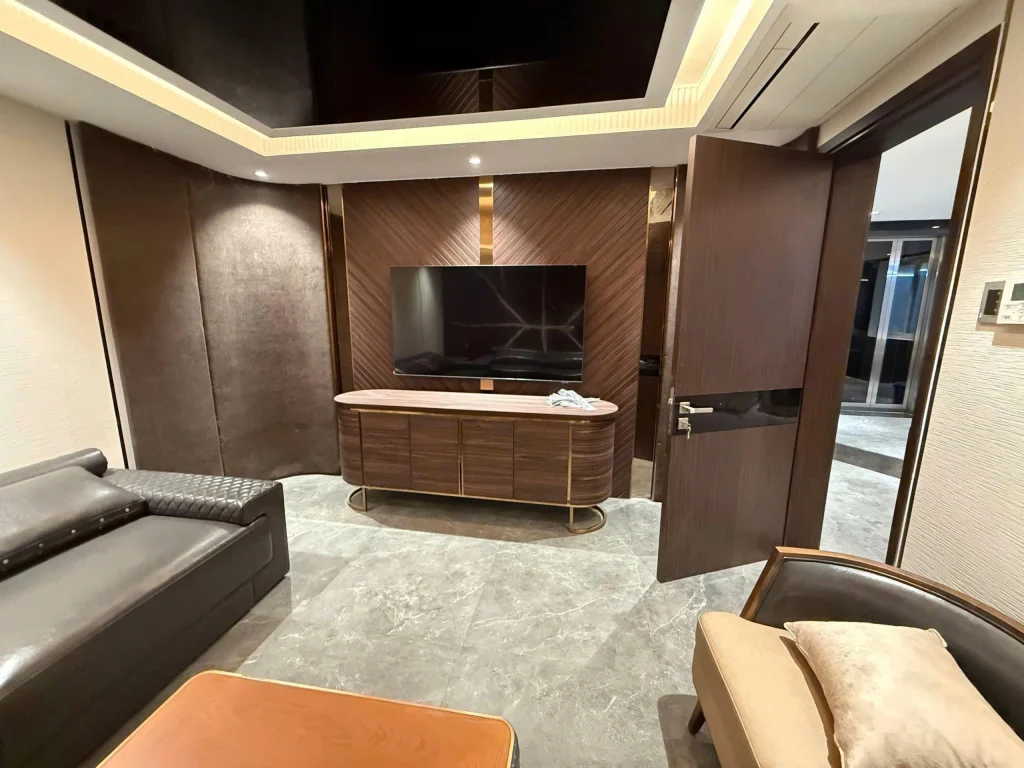 Phòng giải trí biệt thự Sala Thủ Thiêm với sofa da cao cấp và hệ tường ốp gỗ đồng bộ