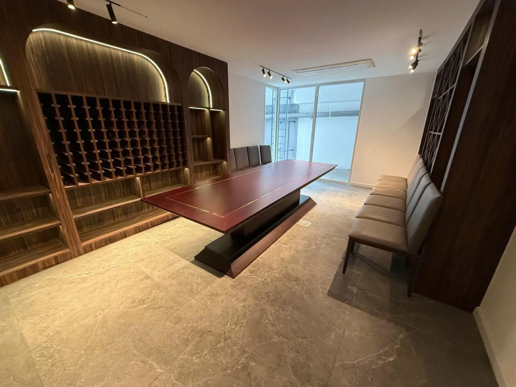 Phòng rượu biệt thự Saroma Villa với tủ trưng bày rượu gỗ sang trọng và bàn dài trung tâm