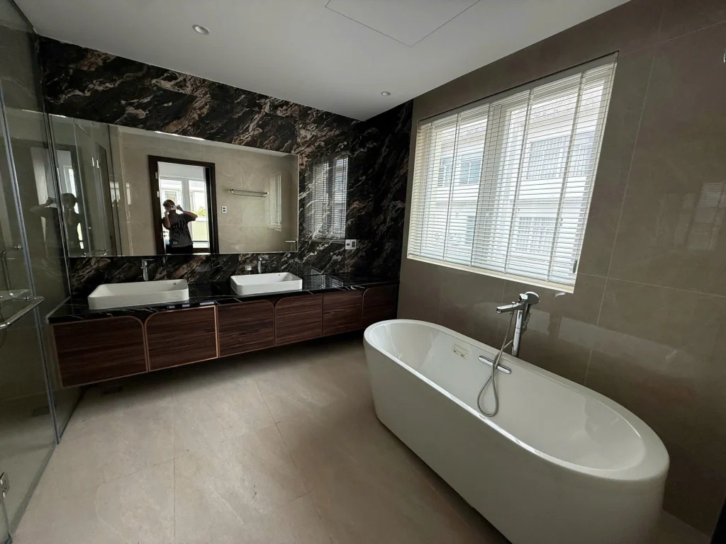Phòng tắm biệt thự Saroma Villa với bồn tắm nằm và tường ốp đá marble đen tự nhiên