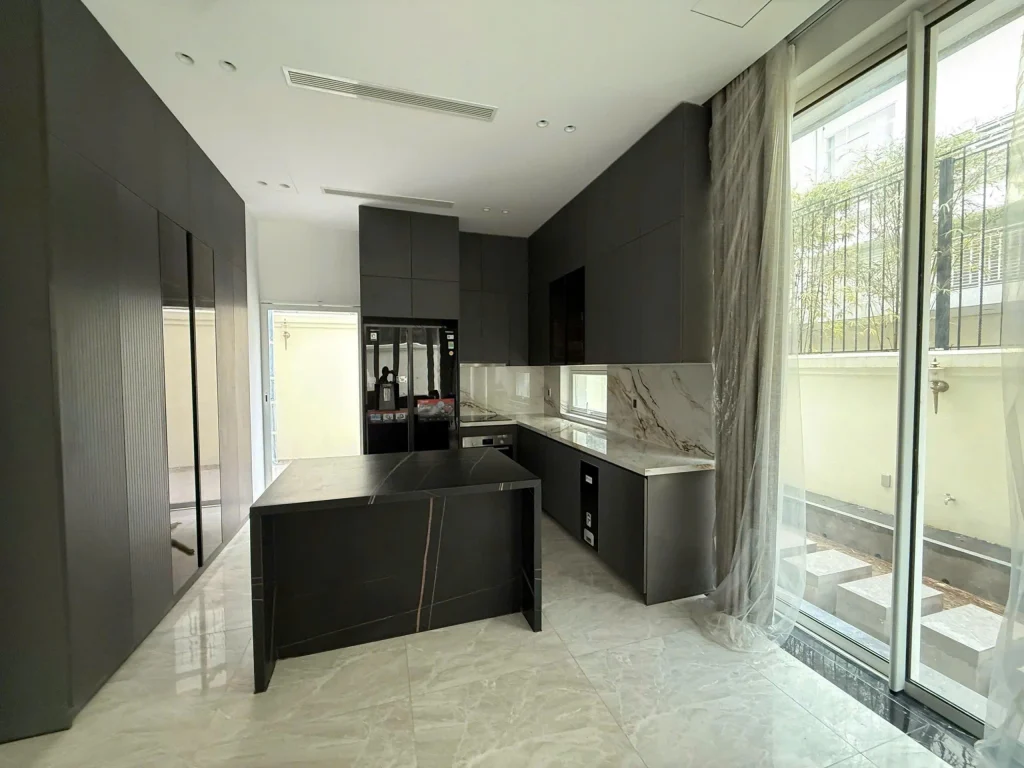 Phòng bếp biệt thự Sala Thủ Thiêm với tủ bếp tone đen và đảo bếp hiện đại