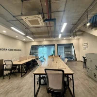 Không gian văn phòng mở tại shophouse Sarica với bàn làm việc dài, tủ cá nhân và cầu thang kết nối các tầng. Ảnh được cung cấp bởi Địa Ốc Sala Thủ Thiêm.