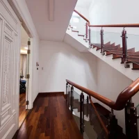 Hành lang tầng lầu biệt thự Saigon Pearl với cầu thang gỗ tay vịn kính