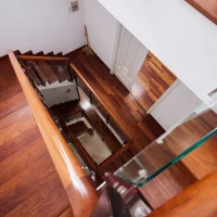 Cầu thang gỗ tay vịn kính trong biệt thự Saigon Pearl